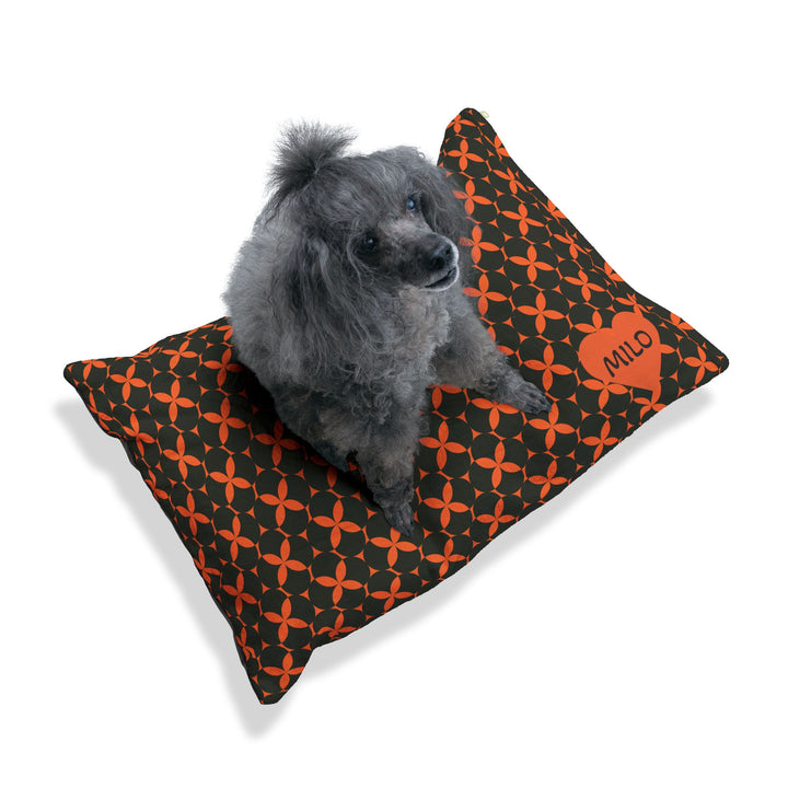 Dog sleeping on black and orange custom pet bed, personalized dog cushion
